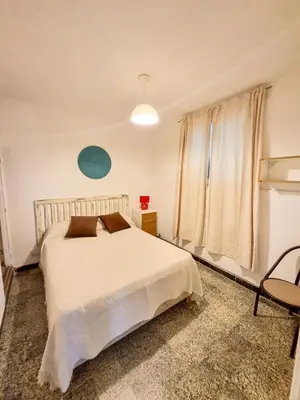 a bedroom with a white bed and a window at Casa Irupé in Embalse