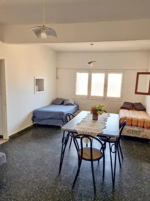 a room with two beds and a table and chairs at Casa Irupé in Embalse