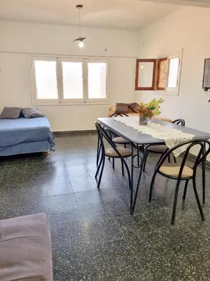 a room with a table and chairs and a bed at Casa Irupé in Embalse
