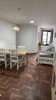 a living room with a table and chairs and a bed at Obispo Oro Departamento Temporario Córdoba in Cordoba