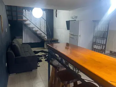 a living room with a table and a refrigerator at Departamento en plena peatonal de Carlos Paz in Villa Carlos Paz