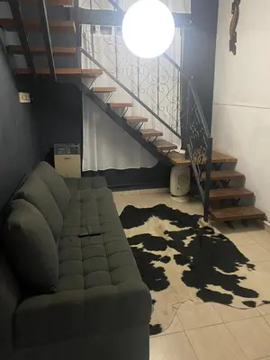 a living room with a couch and a staircase at Departamento en plena peatonal de Carlos Paz in Villa Carlos Paz