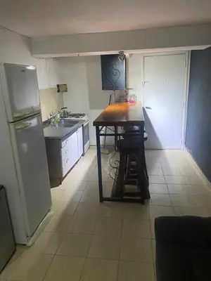 a small kitchen with a table and a refrigerator at Departamento en plena peatonal de Carlos Paz in Villa Carlos Paz
