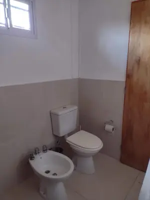 a bathroom with a toilet and a sink at Portal del Sol in Villa Yacanto