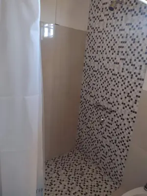 a bathroom with a shower with black and white tiles at Portal del Sol in Villa Yacanto