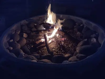 a fire burns in a fire pit with rocks at Portal del Sol in Villa Yacanto