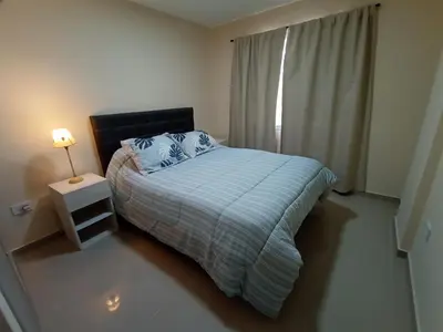 a bedroom with a bed and a lamp and a window at Hermoso Departamento en muy bonita zona de Alta Córdoba, nuevo a estrenar in Cordoba