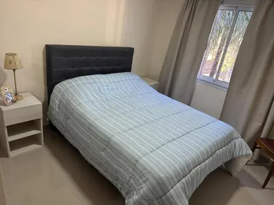a bedroom with a bed with a striped comforter and a window at Hermoso Departamento en muy bonita zona de Alta Córdoba, nuevo a estrenar in Cordoba
