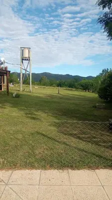 a large field with a water tower in the grass at Cabaña Malibu in Los Reartes