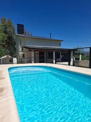 a large blue swimming pool in front of a house at Casa con pileta de uso exclusivo in Tanti