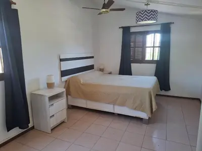 a bedroom with a bed and a dresser and a window at Casa con pileta de uso exclusivo in Tanti
