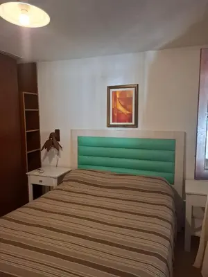 a bedroom with a bed with a green head board at Casa con pileta de uso exclusivo in Tanti