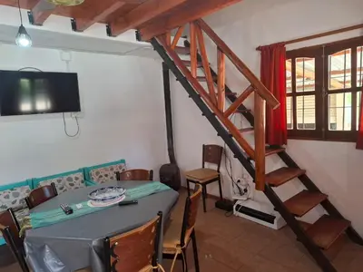 a dining room with a table and a staircase at Casa con pileta de uso exclusivo in Tanti