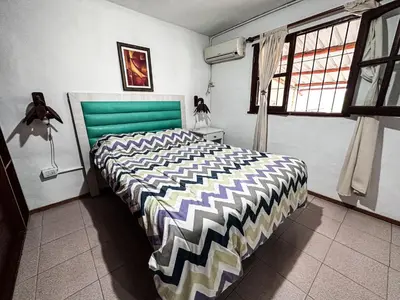 a bedroom with a large bed with a green headboard at Casa con pileta de uso exclusivo in Tanti