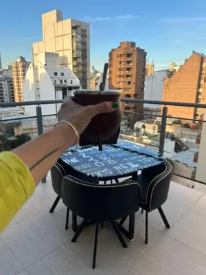a person holding a drink on a table on a balcony at CALASANz PREMIUM in Cordoba
