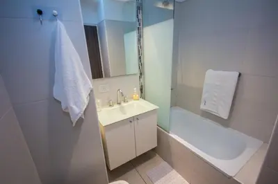 a white bathroom with a sink and a bath tub at Departamento en Nueva Córdoba in Cordoba