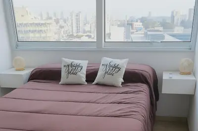 a bedroom with a bed with two pillows saying not fighting epilepsy at Coral State Premium Tower in Cordoba