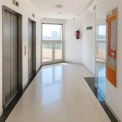 an empty hallway with white tile floors and windows at Coral State Premium Tower in Cordoba