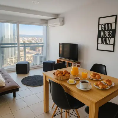 a living room with a table with breakfast foods and orange juice at Coral State Premium Tower in Cordoba