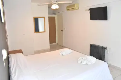 a bedroom with two beds and a tv on the wall at Gran hotel argentino in Villa Carlos Paz