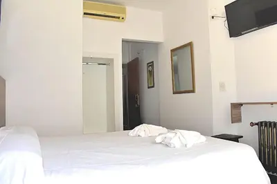 a bedroom with two beds with white sheets at Gran hotel argentino in Villa Carlos Paz