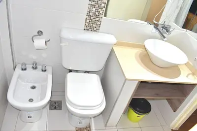 a small bathroom with a toilet and a sink at Gran hotel argentino in Villa Carlos Paz
