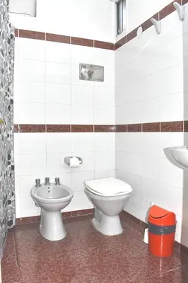 a bathroom with a toilet and a sink at Gran hotel argentino in Villa Carlos Paz