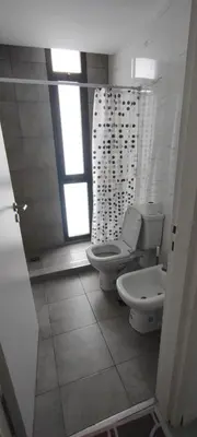 a bathroom with a toilet and a window at Lake in Villa Carlos Paz