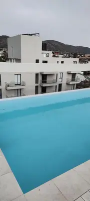 a view of a building from a swimming pool at Lake in Villa Carlos Paz