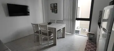 a white dining room table with chairs and a television at Lake in Villa Carlos Paz