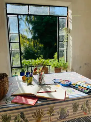 a table with papers and pens and a window at La casita azul, Tanti in Tanti