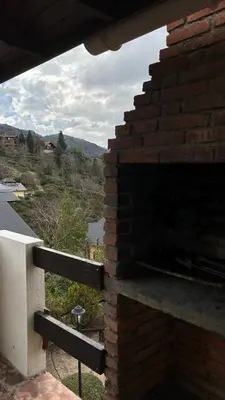 a brick fireplace on the side of a house at Cabañas Rio Manso in La Cumbrecita