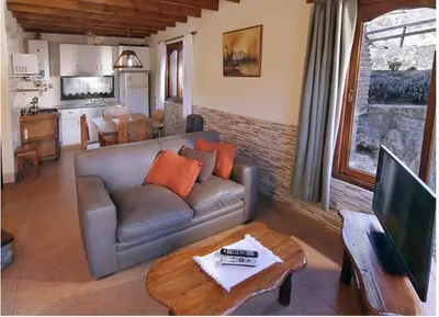 a living room with a couch and a table at Cabañas Rio Manso in La Cumbrecita
