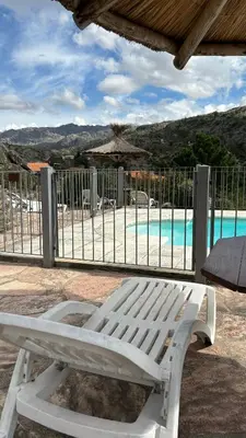 a white bench sitting in front of a pool at Cabañas Rio Manso in La Cumbrecita