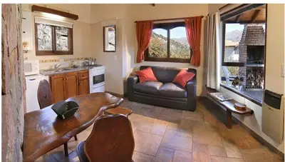a living room with a couch and a table at Cabañas Rio Manso in La Cumbrecita