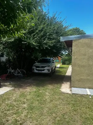 a car parked under a tree in a driveway at Casa en Villa Amancay, Calamuchita in Villa Amancay