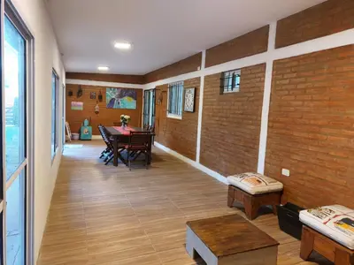 a room with a table and a brick wall at Casa en Villa Amancay, Calamuchita in Villa Amancay