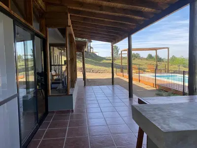 a house with a porch with a view of a pool at Gran Cabaña Dos Yacanto in Villa Yacanto