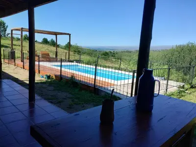 a view of a swimming pool from the window of a house at Gran Cabaña Dos Yacanto in Villa Yacanto