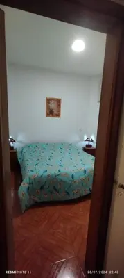 a bedroom with a bed with a blue comforter at Departamento Centrico Cordoba in Cordoba