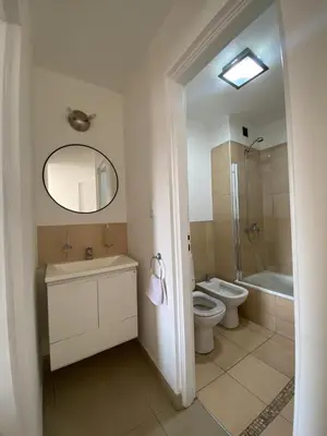 a bathroom with a sink and a toilet and a mirror at Dptos Córdoba -Guemes, Sobre la Cañada, vista al Paseo de Artesanos in Cordoba