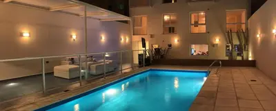 a large swimming pool in a room with a couch at Dptos Córdoba -Guemes, Sobre la Cañada, vista al Paseo de Artesanos in Cordoba