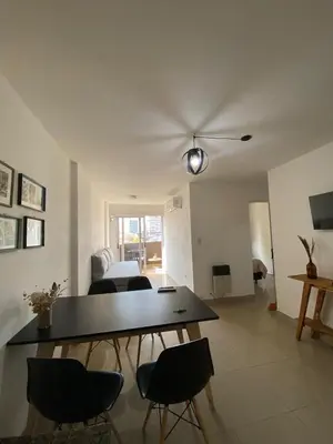 a living room with a table and chairs and a bed at Dptos Córdoba -Guemes, Sobre la Cañada, vista al Paseo de Artesanos in Cordoba