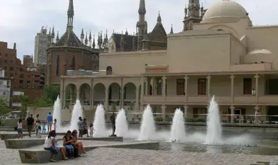 a group of people sitting around a fountain in front of a building at Departamento Amoblado en Nueva Cordoba in Cordoba