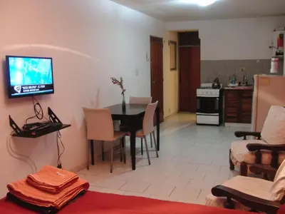 a living room with a table and a tv on the wall at Departamento Amoblado en Nueva Cordoba in Cordoba