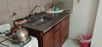 a kitchen with a sink and a stove with a tea kettle at Departamento Amoblado en Nueva Cordoba in Cordoba