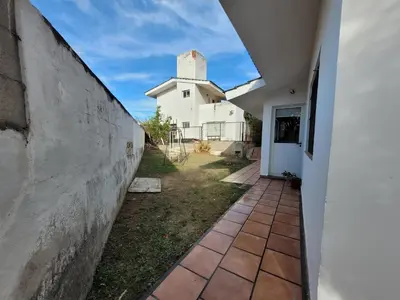 a walkway leading to a white building with a tower at Casa Tío Luis in Villa Carlos Paz
