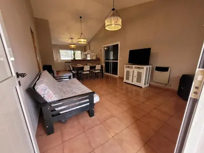 a living room with a couch and a tv at Casa Tío Luis in Villa Carlos Paz