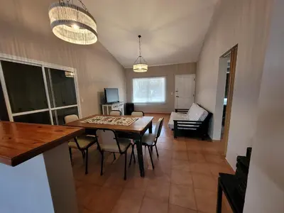 a dining room and living room with a table and chairs at Casa Tío Luis in Villa Carlos Paz