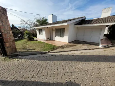 a small white house with a brick driveway at Casa Tío Luis in Villa Carlos Paz